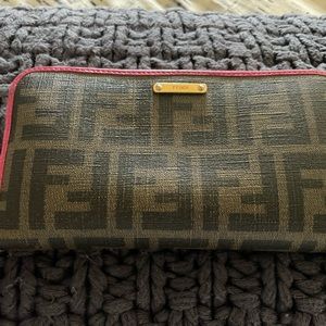 Large zip around wallet. Brown logo with pink trim.